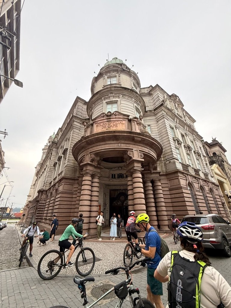 Ciclistas diante do edifício da Bolsa Oficial de Café em Santos
