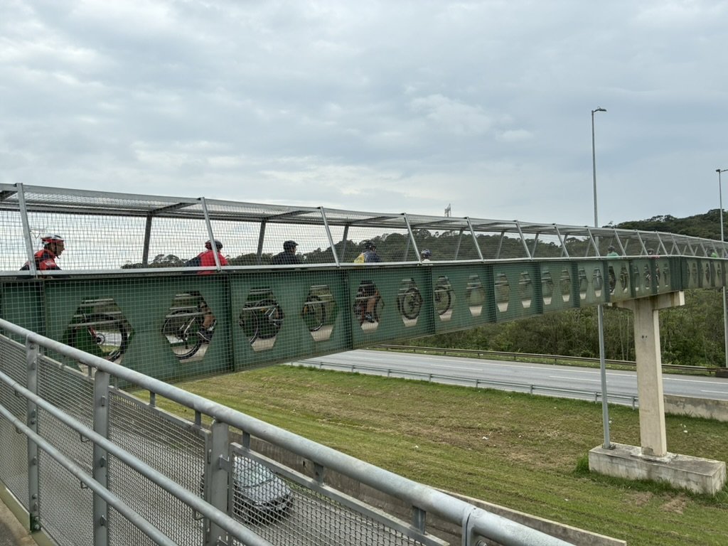 Grupo atravessando uma passarela com bicicletas